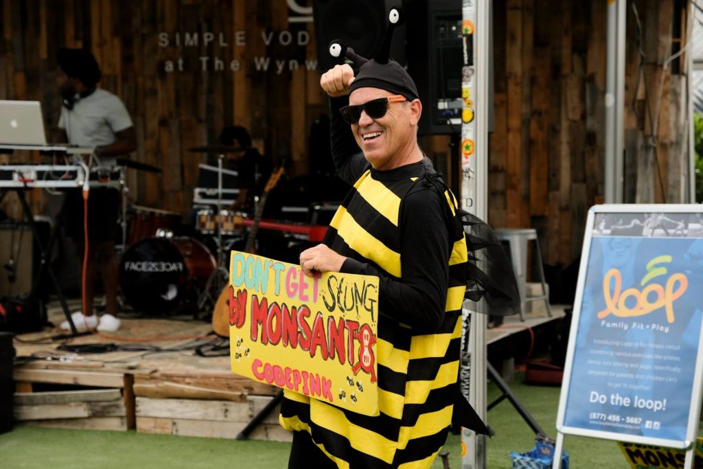 Man dressed as a bumble bee, holding a sign tat reads " don't get stung by monsanto" 
