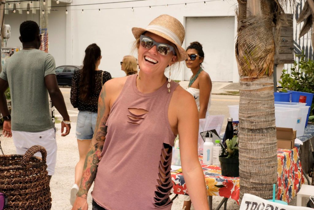 A smiling woman in a hat and sunglasses. 