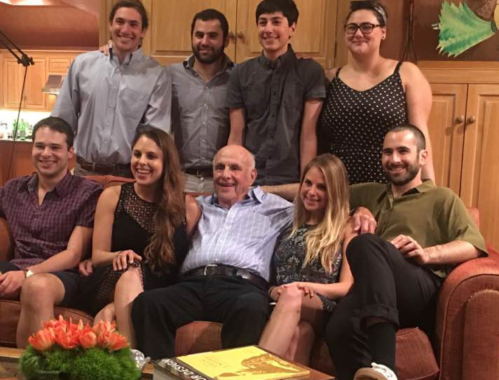 Della Heiman sits next to her grandfather, who is surrounded by his grandchildren at Passover. 